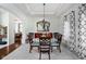 Formal dining room with tray ceiling, chandelier, and an elegant glass-topped table with ornate chairs at 9626 Oakhaven Ct, Indianapolis, IN 46256