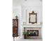 Elegant living room featuring a fireplace with decorative mantel, ornate mirror, and classic cabinet at 9626 Oakhaven Ct, Indianapolis, IN 46256
