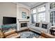 Cozy living room with a fireplace, large windows, and elegant furnishings for relaxation and comfort at 9626 Oakhaven Ct, Indianapolis, IN 46256