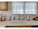Close up of a clean, white, kitchen sink with a goose neck faucet and window view at 990 Bull Run W Dr, Greenwood, IN 46143