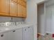 Convenient laundry room with full-size washer, dryer, and wood cabinets at 990 Bull Run W Dr, Greenwood, IN 46143