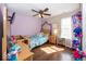 Light-filled bedroom featuring a ceiling fan, hardwood floors, and a playful decor, perfect for a space at 10208 Clear Sky Dr, Avon, IN 46123