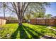 Spacious backyard with lush green grass, a large tree, and a wooden fence at 1031 N Lesley Ave, Indianapolis, IN 46219