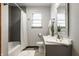 Neutral bathroom with a shower/tub, grey tile, mosaic flooring, and a single sink vanity at 1031 N Lesley Ave, Indianapolis, IN 46219