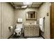 Bathroom with striped wallpaper, neutral vanity, and a wicker basket filled with towels at 1031 N Lesley Ave, Indianapolis, IN 46219