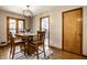 Warm dining room with wooden table set for four, with patterned rug, and wooden door leading to another room at 1031 N Lesley Ave, Indianapolis, IN 46219