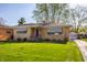 A classic brick home with awnings, complemented by a lush green lawn at 1031 N Lesley Ave, Indianapolis, IN 46219