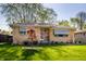 Well-kept ranch-style home with a neat lawn, manicured shrubs, and classic brick facade at 1031 N Lesley Ave, Indianapolis, IN 46219