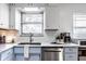 Bright kitchen featuring stainless steel appliances, gray countertops, and light blue cabinets, with a window over the sink at 1031 N Lesley Ave, Indianapolis, IN 46219