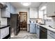 Modern kitchen with stainless steel appliances, light blue cabinets and decorative accessories, with view into dining room at 1031 N Lesley Ave, Indianapolis, IN 46219