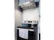 Close up of modern stove with stainless steel vent hood and subway tile backsplash, accented with a cooking themed towel at 1031 N Lesley Ave, Indianapolis, IN 46219