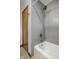 Shower and tub with grey tile and a showerhead with various spray settings at 1031 N Lesley Ave, Indianapolis, IN 46219