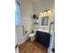 Classic bathroom with blue vanity, grab bar, and wood floors at 1041 Hervey St, Indianapolis, IN 46203