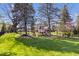 Large backyard featuring mature trees, a playset, and a black fence along the property line at 10417 Mayapple Ct, Noblesville, IN 46060