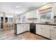 Well-lit kitchen featuring white cabinets, black countertops, and an open dining area at 10417 Mayapple Ct, Noblesville, IN 46060