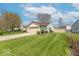 Single-story home with a long driveway, two car garage, and a sprawling green lawn at 105 Fountain Dr, Mooresville, IN 46158