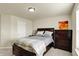 A cozy bedroom featuring a dark wood bed frame and a neutral-colored wall with modern art at 10811 Wild Orchard Ln, Indianapolis, IN 46239