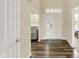 Bright foyer with dark wood floors, white front door with windows and neutral paint at 10811 Wild Orchard Ln, Indianapolis, IN 46239