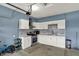 Garage kitchen with white cabinetry, stainless appliances, gray tile backsplash and utility sink at 10811 Wild Orchard Ln, Indianapolis, IN 46239