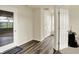 Hallway featuring a sliding glass door, neutral paint, and wood flooring at 10811 Wild Orchard Ln, Indianapolis, IN 46239
