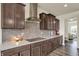 Modern kitchen featuring a stainless steel range hood, white countertops, and dark cabinetry at 10811 Wild Orchard Ln, Indianapolis, IN 46239
