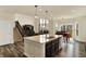 Open-concept kitchen and living area with a center island and staircase at 10811 Wild Orchard Ln, Indianapolis, IN 46239