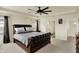 Spacious primary bedroom featuring dark wood furniture, a tray ceiling with fan and an ensuite bathroom at 10811 Wild Orchard Ln, Indianapolis, IN 46239