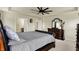 Spacious primary bedroom featuring dark wood furniture, a tray ceiling with fan and access to the ensuite at 10811 Wild Orchard Ln, Indianapolis, IN 46239