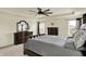 Spacious primary bedroom featuring dark wood furniture, a tray ceiling with fan and large windows at 10811 Wild Orchard Ln, Indianapolis, IN 46239