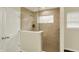 The sleek and stylish shower features a clear glass enclosure and tiled walls with a decorative window at 10811 Wild Orchard Ln, Indianapolis, IN 46239