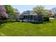 Lush backyard with the screened in porch, expansive deck, and mature landscaping and green lawn at 10844 Bentwater Ln, Fishers, IN 46037