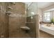 Modern bathroom with glass enclosed shower, soaking tub and stone tile flooring at 10844 Bentwater Ln, Fishers, IN 46037