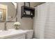 Stylish bathroom offers modern vanity, round mirror, decorative shelf, and shower-tub combination at 10844 Bentwater Ln, Fishers, IN 46037