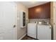 Bright laundry room features modern washer and dryer, updated cabinets, and wood-look flooring at 10844 Bentwater Ln, Fishers, IN 46037