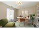 Bright home office features a work space, a green chair, and large windows at 10844 Bentwater Ln, Fishers, IN 46037