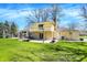 Outdoor fire pit on a large lawn featuring a two-story house with a balcony and patio area with dining furniture at 11006 Timber Ln, Carmel, IN 46032