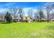 Expansive backyard featuring a large lawn, patio area, and two-story home with a balcony and stone accents at 11006 Timber Ln, Carmel, IN 46032
