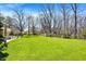 Lush backyard with a large grassy area, mature trees, and outdoor seating at 11006 Timber Ln, Carmel, IN 46032