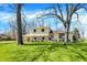 Attractive two-story home framed by mature trees and a green lawn, showcasing a well-maintained landscape at 11006 Timber Ln, Carmel, IN 46032
