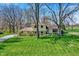 Aerial view showcasing a two-story house with a well-maintained lawn, mature trees, and close proximity to a golf course at 11006 Timber Ln, Carmel, IN 46032