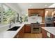 Well-lit kitchen featuring stainless steel appliances, white countertops, and a window overlooking a backyard at 11006 Timber Ln, Carmel, IN 46032