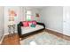 Bright bedroom with a cozy daybed, wood floors, neutral walls, and stylish floral artwork at 11359 Peacock Dr, Indianapolis, IN 46236