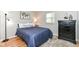 Comfortable bedroom with warm wood floors, blue bedding, and a sleek black dresser at 11359 Peacock Dr, Indianapolis, IN 46236
