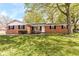 Charming single-story brick home featuring a well-manicured lawn and mature trees at 11359 Peacock Dr, Indianapolis, IN 46236