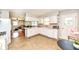 Bright kitchen featuring white cabinets, appliances, and an adjacent dining area at 11359 Peacock Dr, Indianapolis, IN 46236