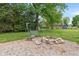 Private yard features a wood swing set and a stone firepit at 11415 Central E Dr, Carmel, IN 46032