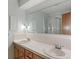 Bathroom featuring dual sinks, a large mirror, tiled countertops, and a shower at 11415 Central E Dr, Carmel, IN 46032