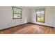 Sunlit bedroom boasts hardwood floors, windows with decorative valances, and ample natural light at 11415 Central E Dr, Carmel, IN 46032