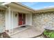 Covered front porch with stone veneer, white posts, and a red front door enhances curb appeal at 11415 Central E Dr, Carmel, IN 46032