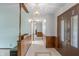 Hallway with wood-paneled wainscoting, ceramic floors, and decorative lighting at 11415 Central E Dr, Carmel, IN 46032